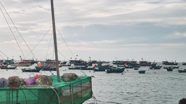Lobster farming cages and colorful buoys structure floating on the sea at a coastal village