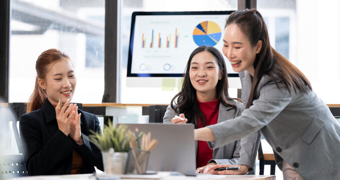 Asian Business Team Smiling and Applauding While Looking at Laptop Screen in Office