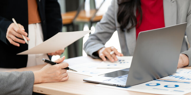 Close Up Business Team Hands Holding Pens and Paper Working with Laptop