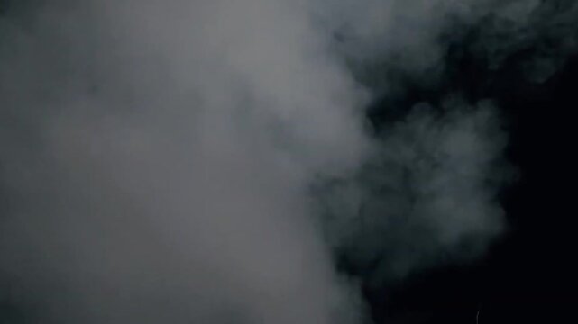 White smoke or fog rolling on a black background loop