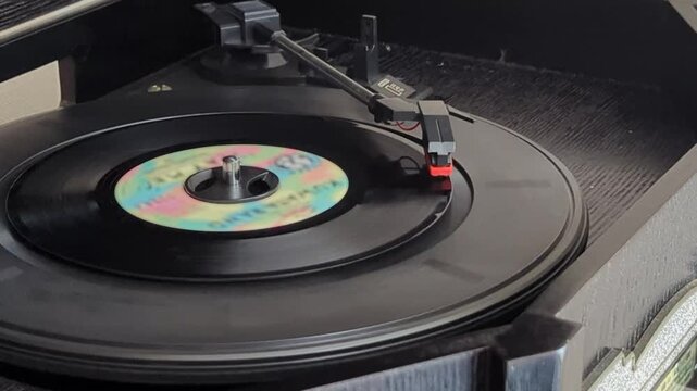 ターンテーブルで回転するドーナツ盤レコードと音楽を再生するレコード針