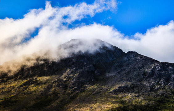 Dramatic cloudscape at sunrise over the glacial rock peaks of Chugach Mountains in Anchorage, Alaska, a summer morning landscape view from Glen Alps Hiking Trail