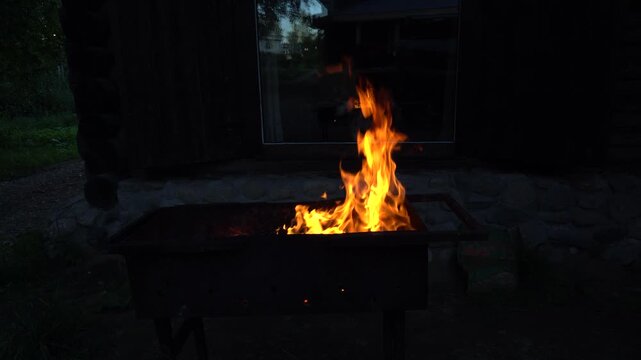 Burning fire in a traditional metal mangal grill outdoors