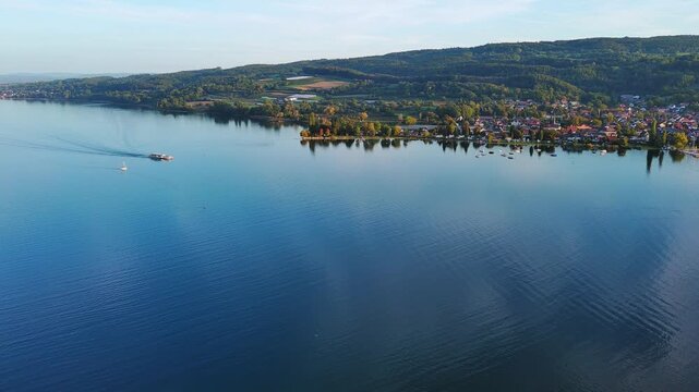 Aerial View of Passenger Boat Cruising on Serene Lake and Coastal Town