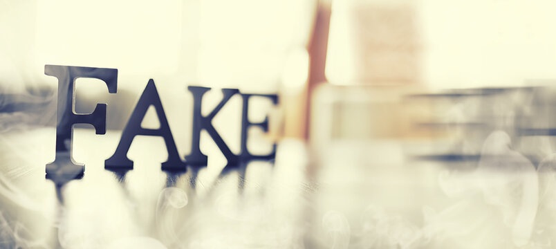 The concept of modern information technology. Fake and facts in the news. The letters spelled the word fake.