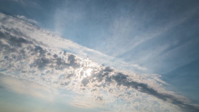 Timelapse of beautiful blue sky with clouds on bright sunny day Sun rays emerge through the clouds.