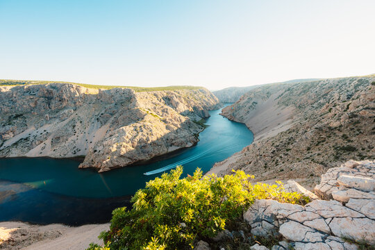 View of the Zrmanja River Canyon in Croatia, with winding turquoise waters cutting through limestone cliffs. A scenic natural wonder popular for kayaking and hiking