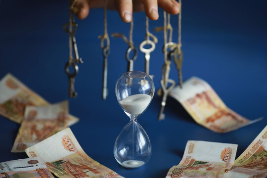 Retro keys on ropes in hand. Flying banknotes. Concept of business ideas.