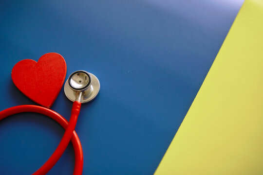 Doctor`s desk in the clinic's office. Stethoscope, puzzle heart, prescriptions on the table.