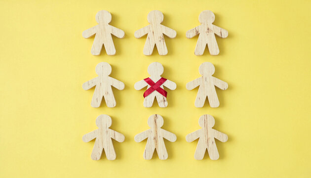 Exclusion concept with wooden figure marked by red x among group on yellow background