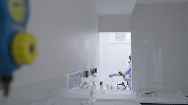 Bright tiled reprocessing room with sinks hoses and endoscopes being cleaned