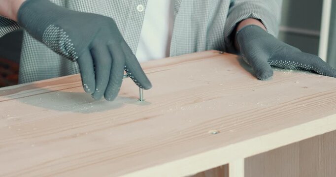 A man assembling a wooden bookshelf