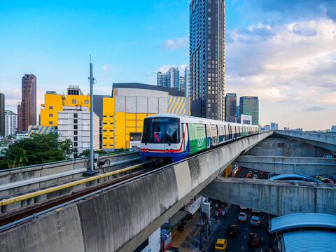 Bangkok, Thailand - July 8, 2026 :  The BTS Skytrain runs in and out of Ha Yaek Lat Phrao Station in the evening, offering views of office buildings and beautiful scenery.