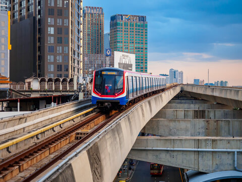Bangkok, Thailand - July 8, 2026 :  The BTS Skytrain runs in and out of Ha Yaek Lat Phrao Station in the evening, offering views of office buildings and beautiful scenery.