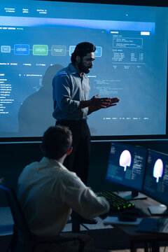 Indian Male Engineer Discussing System Monitoring Dashboard During Software Development Meeting. Developer Presenting Technical Results and Programming Strategy to Colleagues.