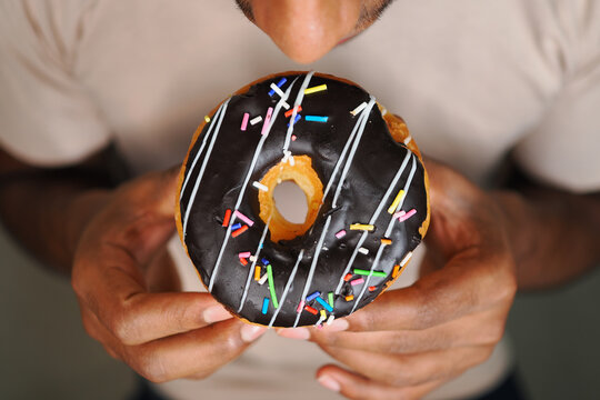Person holding a donut and getting ready to eat