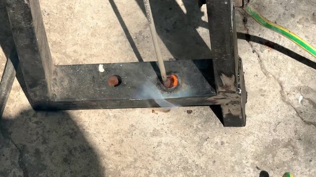 Welding electrode burning hole through thick metal pipe outdoors close up macro concept for arc cutting, metalworking technique, high temperature heat, fabrication. 4k High quality