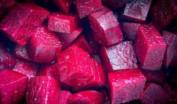 A textured background of red beetroot cubes.