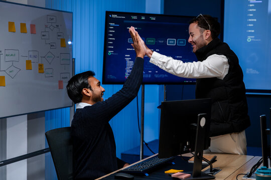 Software Developers Celebrating Successful Application Launch, Giving High Five and Showing Team Achievement After Completing Programming Project in Modern Technology Office.