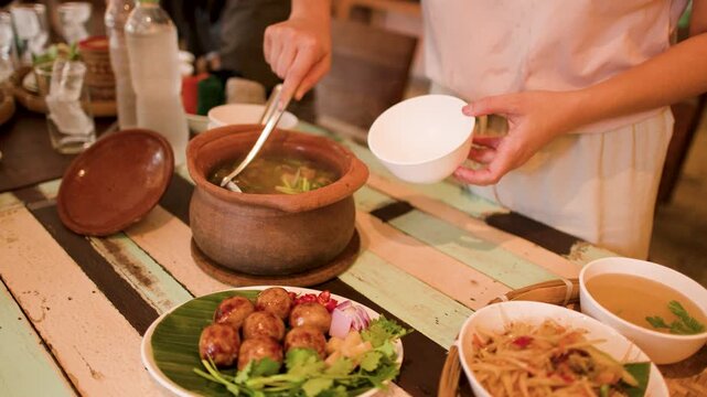 Serving Traditional Thai Isan Food From Clay Pot in Bangkok