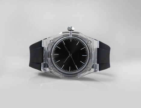 Black Analog Wristwatch with Transparent Case and Minimalist Black Strap on White Background