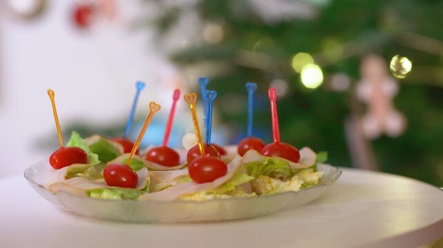 Festive Holiday Appetizers Rotating on a Plate with Christmas Tree Background