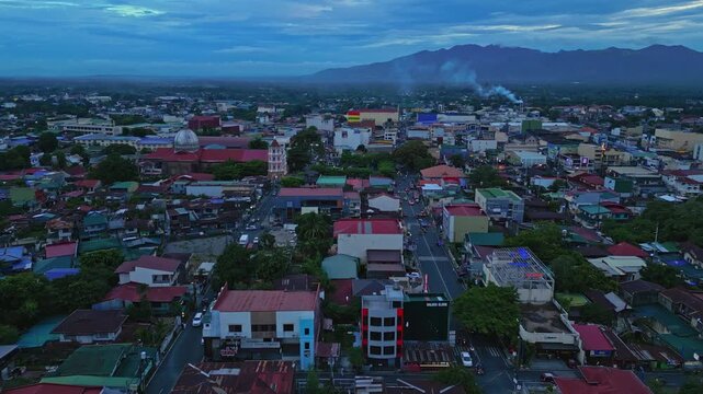 Wide aerial landscape shot of Iglesia Ni Cristo near Sampaloc Lake in San Pablo City, Laguna, Philippines showcasing the church complex, nearby residential areas, greenery, and Mount San Cristobal.