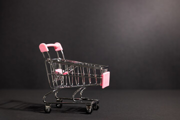 Empty miniature shopping cart on dark background with copy space for retail sale ecommerce or product promotion mockup © Svetlana Kolpakova