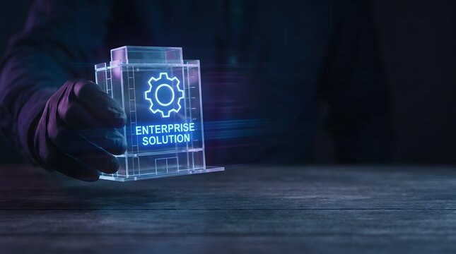 Person holding a glowing transparent model of a building with gear icon