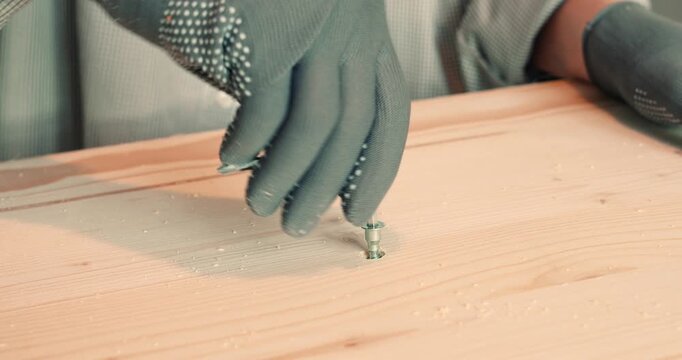 A man assembling a wooden bookshelf