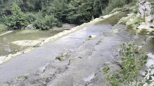 Inquadratura diagonale dello scorrimento dell'acqua della Cascata del Sasso a Sant'Angelo in Vado, nelle Marche