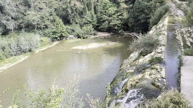 Panoramica aerea della storica diga e del bacino fluviale della Cascata del Sasso a Sant'Angelo in Vado, immersi nella natura incontaminata delle Marche