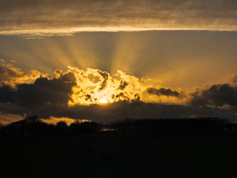 Dramatic sun rays breaking through storm clouds