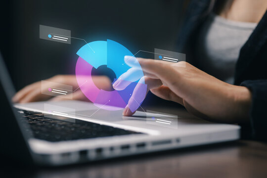 Businesswoman interacts with a virtual donut chart over laptop, representing data analytics, business intelligence, digital dashboard, statistics, technology, insights, and performance.