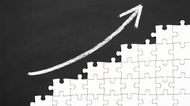 White puzzle pieces stairway going up with drawn chalk arrow success
