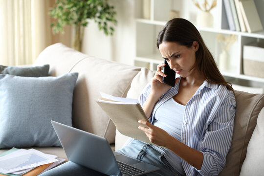 Disappointed teleworker checking inform during phone call