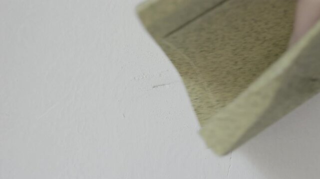 Detail of sandpaper on white wall