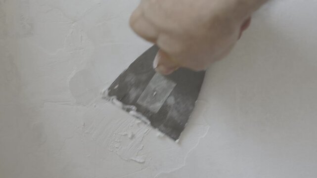 Filling wall cracks with putty and spatula
