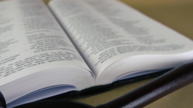 Open Holy Bible with a judge's wooden gavel resting nearby on a desk, symbolizing the intersection of divine law, justice, faith, and the legal system with a focus on morality and truth
