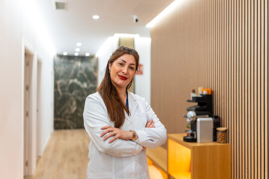 Female doctor standing arms crossed in modern aesthetic clinic