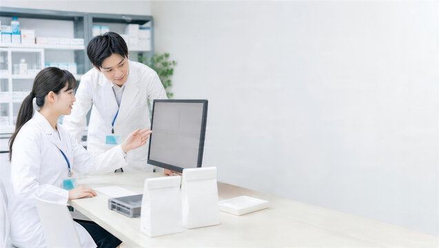 薬局スタッフがタブレットの業務手順を相互確認する