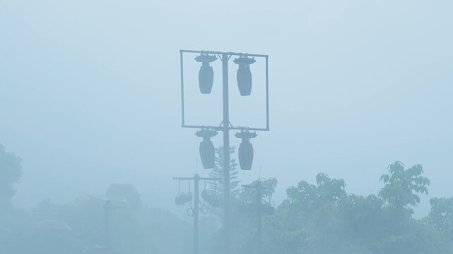 Handheld medium shot of a silhouette park signpost enveloped in thick mountain fog
