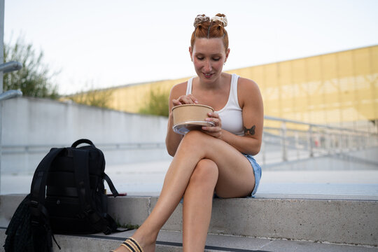 Young white woman sitting on urban steps