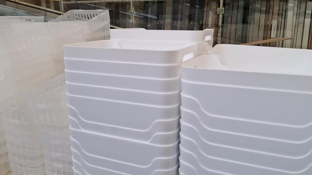 White and clear plastic organizer baskets stacked in rows in a retail store. Home organization products, storage containers retail display, household goods shop.