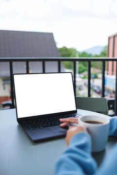 Vertical mockup image of a woman working on laptop computer with blank white desktop screen while drinking coffee in cafe