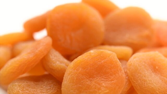 Dried apricots close-up. Apricot dried fruits isolated on white background. Ripe Organic Apricots fruit rotating. Close up. Heap of dried apricot. Vegan food, fiber. Rotating border design. 