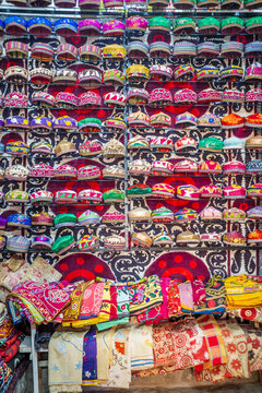 Colorful collection of traditional Uzbek embroidered caps and handcrafted textiles displayed at a local bazaar in Uzbekistan. Vibrant patterns, intricate embroidery, and richly decorated fabrics