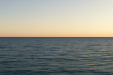 Fototapeta premium Minimalist Flat Ocean Horizon at Warm Sunset twilight with Gentle Water Ripples