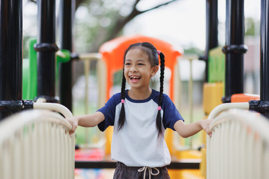 Asian girl smiling and laughing playing on playground