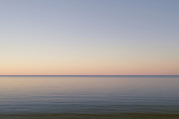 Fototapeta premium Peaceful Pastel Sunset Horizon Over Still Ocean Waters